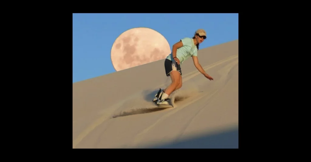 una dona fa snowboard en una duna de sorra