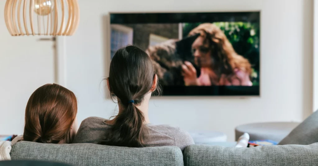 dues dones assegudes mirant la televisió