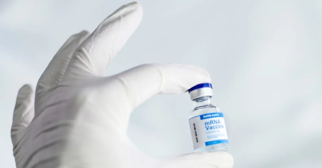 ma amb guant de cautxú amb un vial de vacuna nra