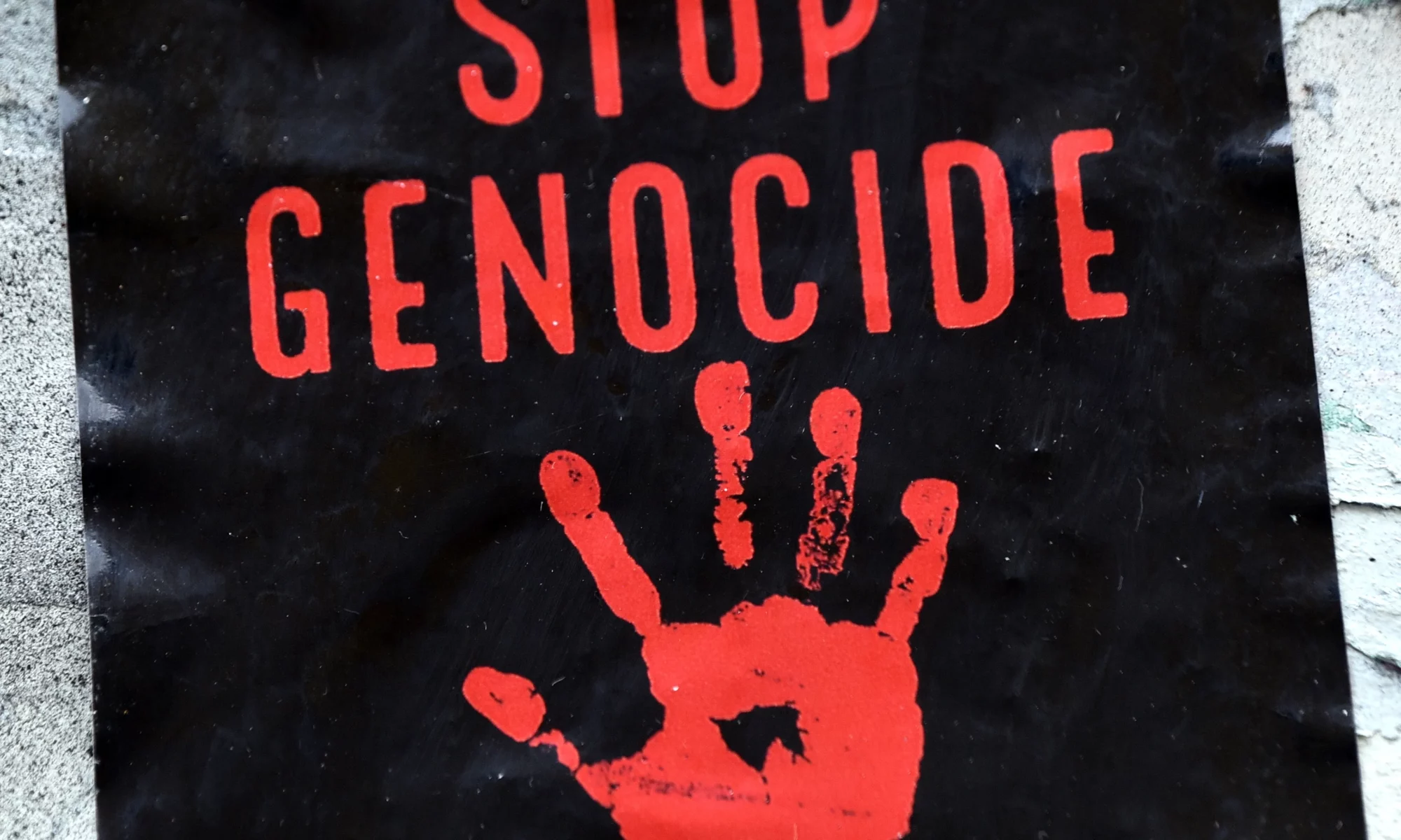 Sticker an einer Mauer "Stop Genocide"