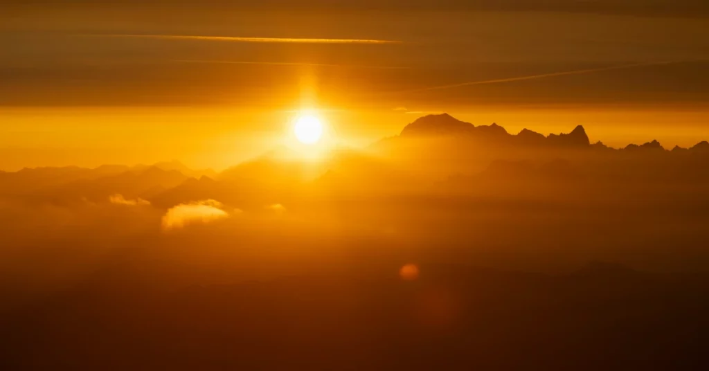 el sol surt entre nuvols daurats